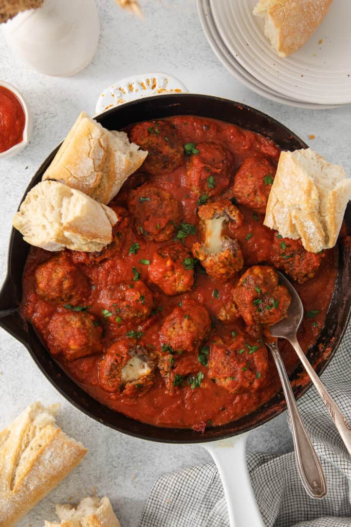 meatballs in tomato sauce in a skillet with bread.