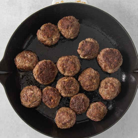 meatballs in a skillet on a white background.