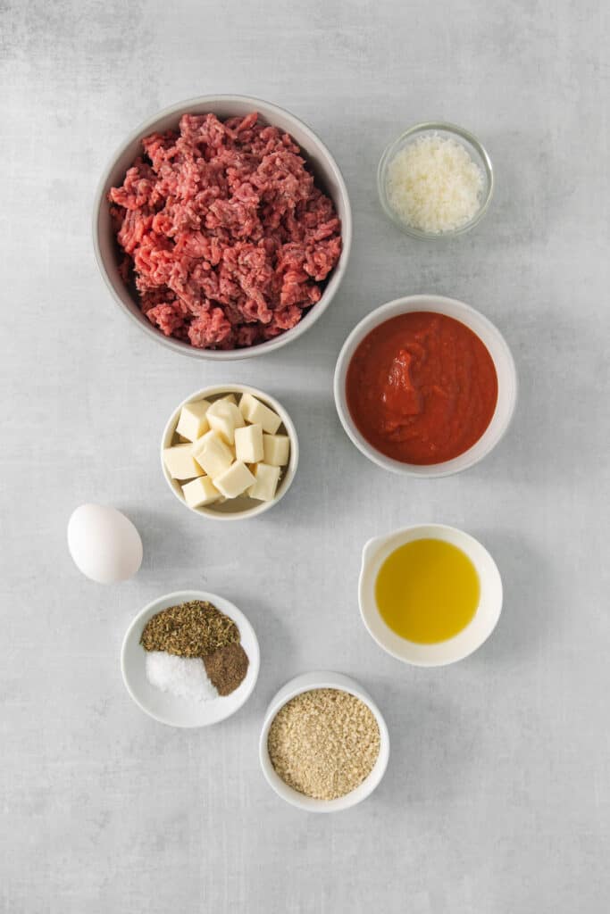 ingredients for meatballs on a grey background.