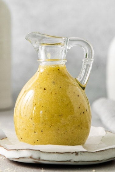 a bottle of mustard sitting on top of a plate.