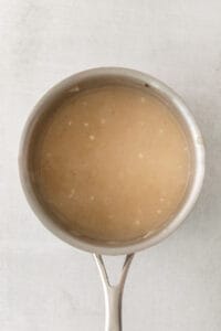 a saucepan with a brown liquid inside of it.