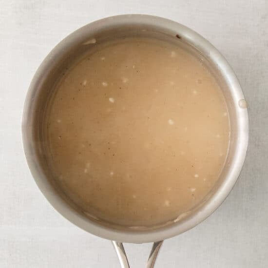 a saucepan with a brown liquid inside of it.