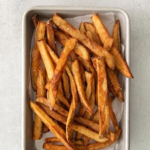 a tray of french fries sitting on top of a table.