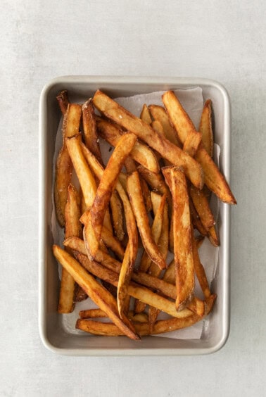 a tray of french fries sitting on top of a table.
