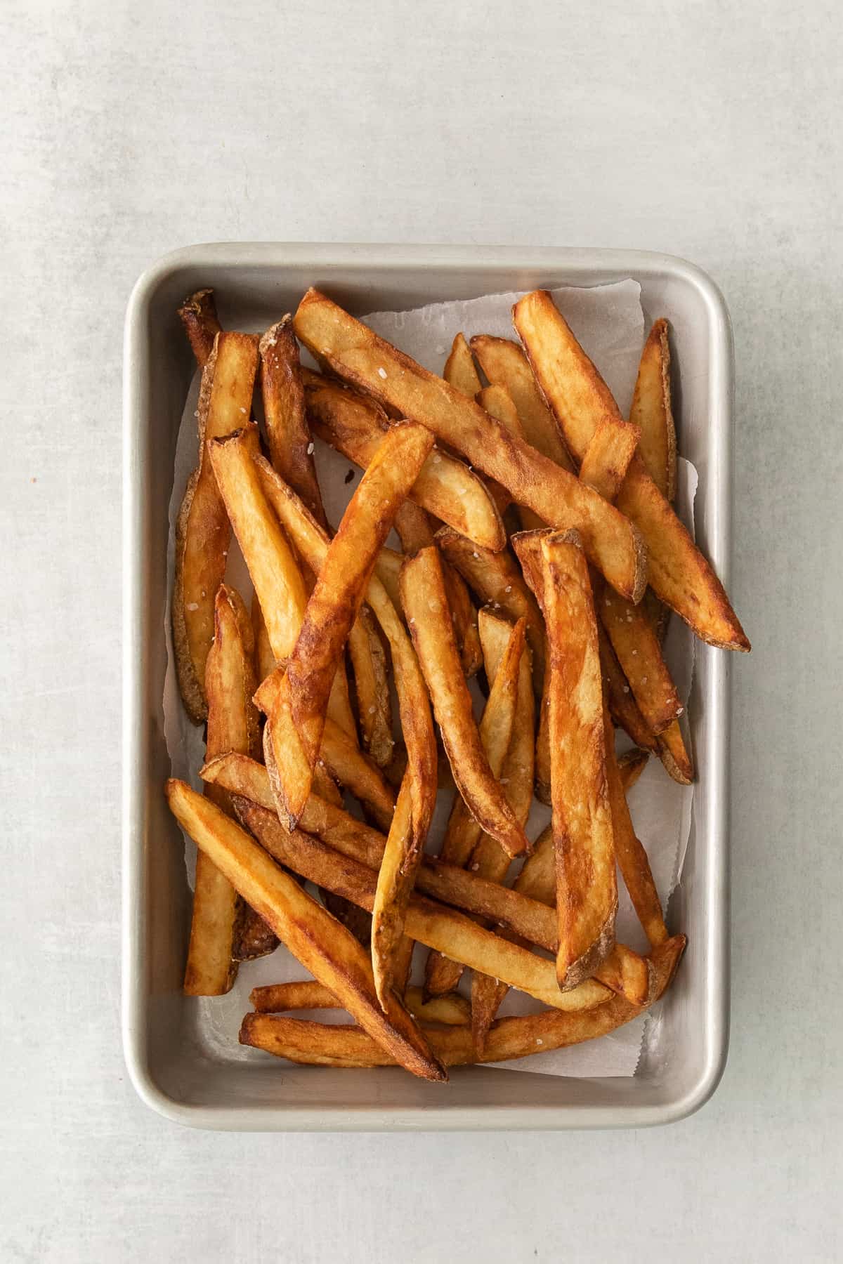 a tray of french fries sitting on top of a table.