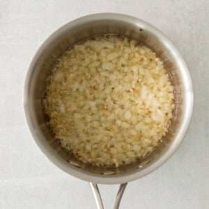 a pan filled with rice on top of a wooden table.