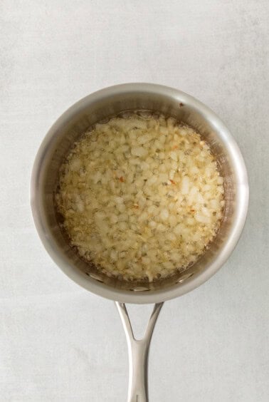 a pan filled with rice on top of a wooden table.