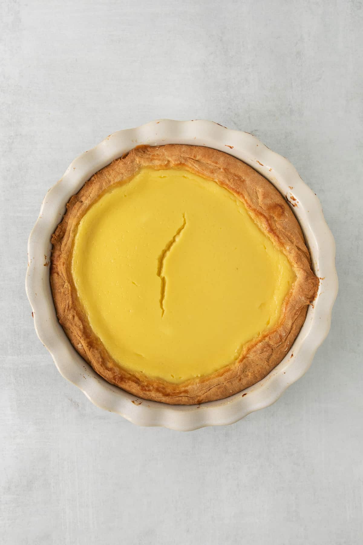 This easy ricotta pie is super creamy and decadent! You'll love this simple dessert with an easy to make homemade crust. Enjoy! Ricotta pie baked in a pie tin.