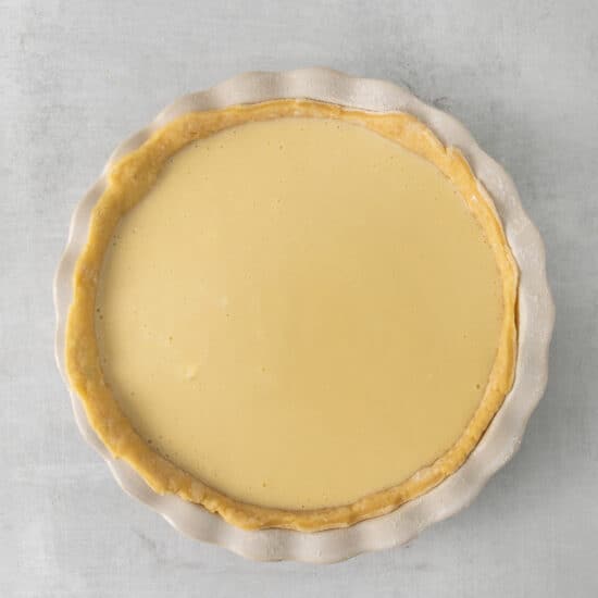 a pie with a yellow filling on a white surface.
