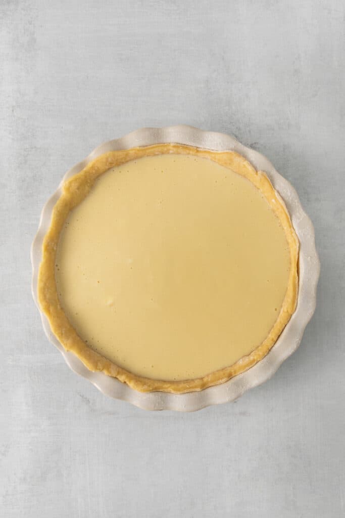 Ricotta pie in a pie plate before baking.
