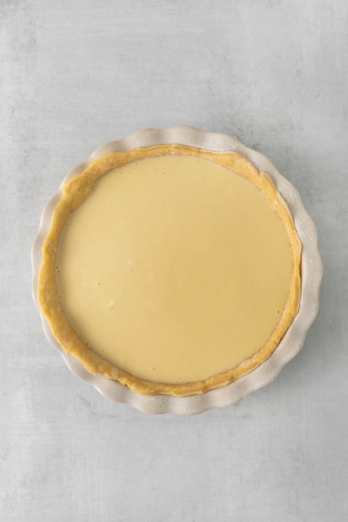 This easy ricotta pie is super creamy and decadent! You'll love this simple dessert with an easy to make homemade crust. Enjoy! Ricotta pie in a pie plate before baking.