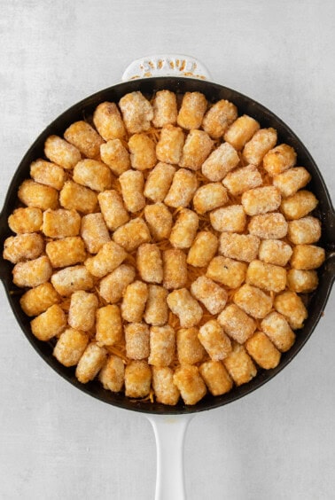 cheesy tater tots in a skillet.
