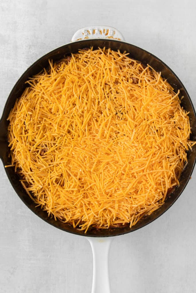 a skillet filled with cheesy nachos.