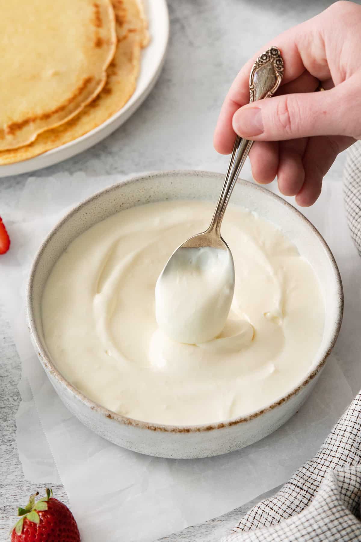 Strawberry crepe filling on a spoon.