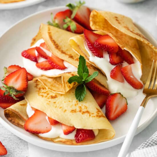 Strawberry cream cheese crepes on a plate.