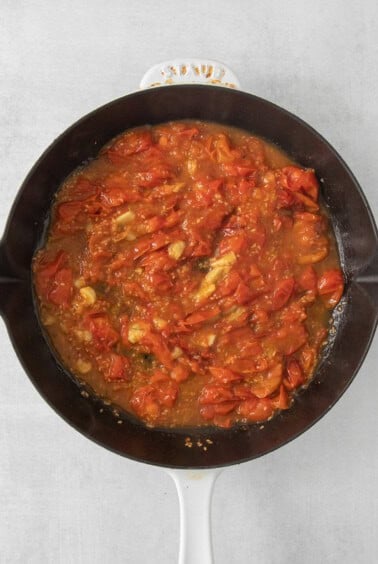 a skillet filled with tomato sauce on a table.