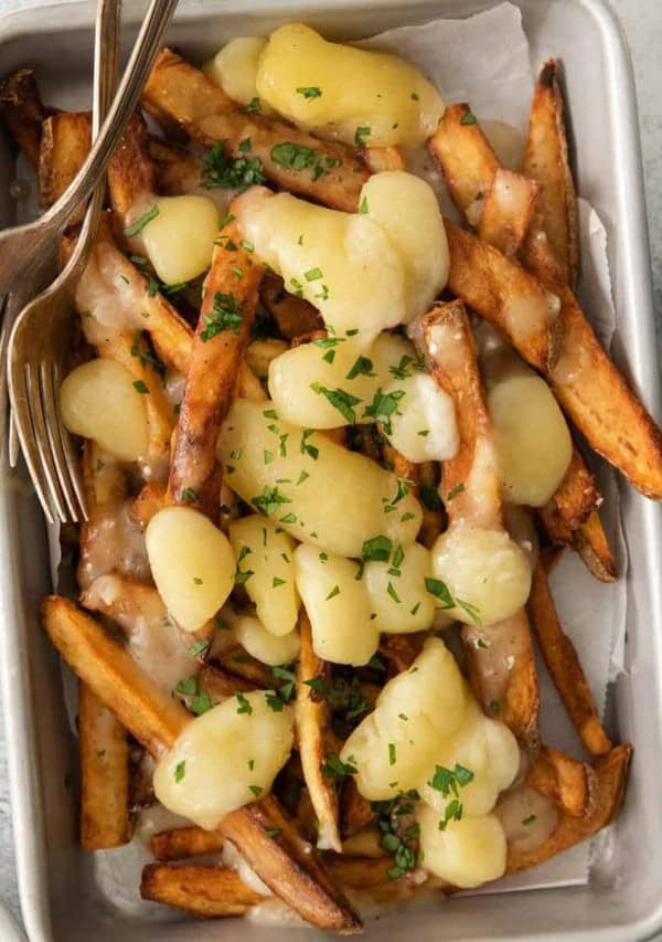 a plate of french fries with cheese and parmesan.