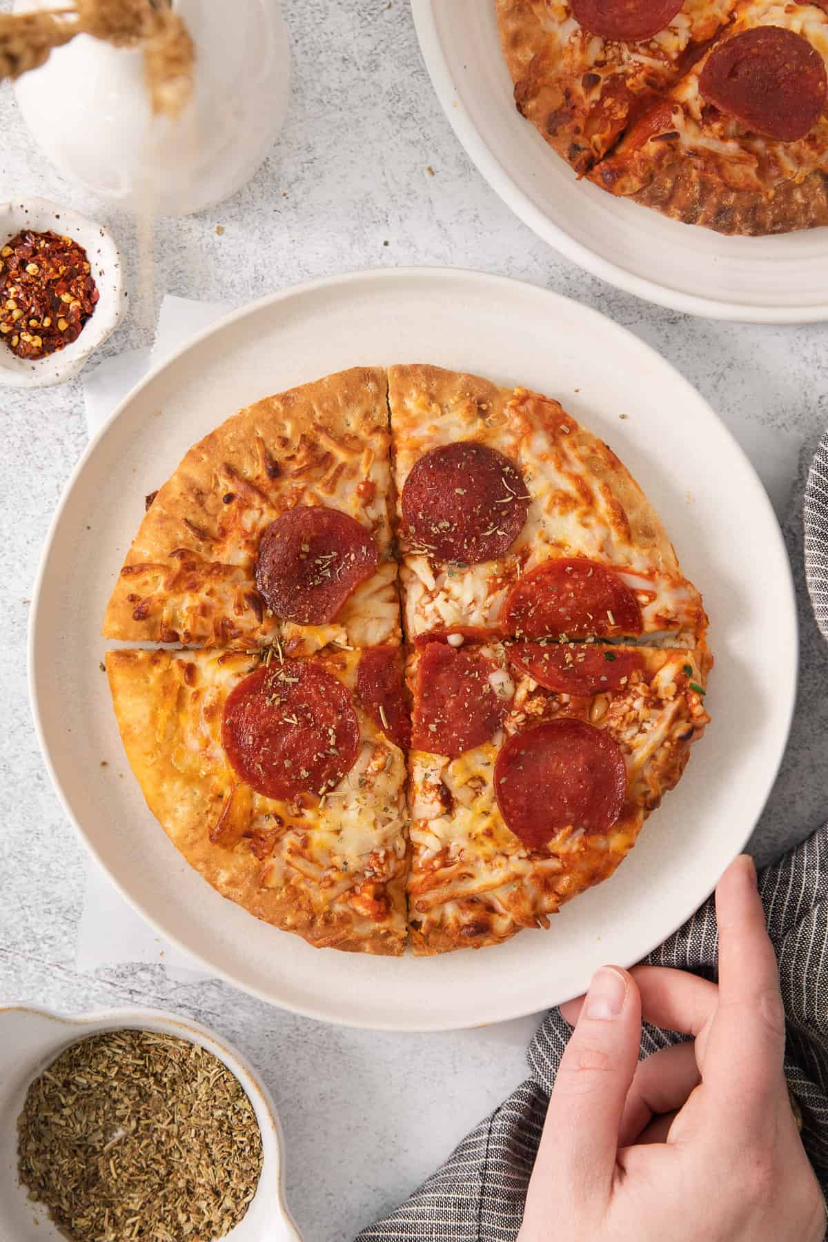 Ai fryer pizza on a plate cut into slices.