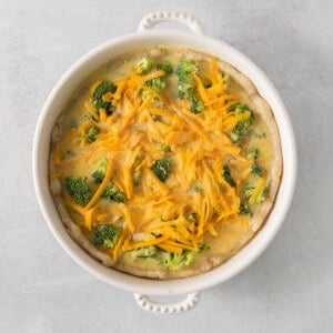 a casserole dish with cheese and broccoli.