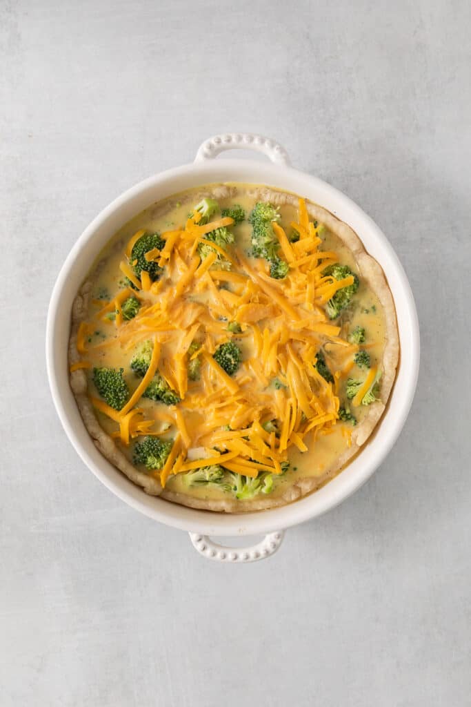a casserole dish with cheese and broccoli.