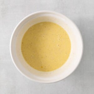 a white bowl filled with soup on top of a table.