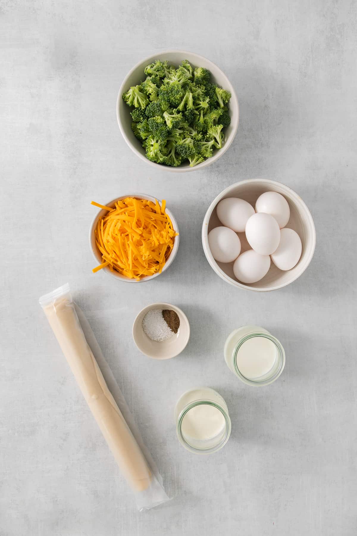 A table with bowls of food and a rolling pin.