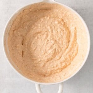 a bowl of hummus sitting on top of a table.