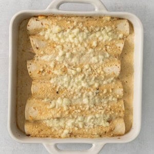 cheesy enchiladas in a white baking dish.