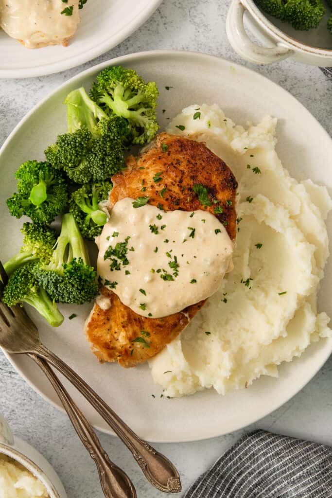 chicken breast with mashed potatoes and gravy on a plate.