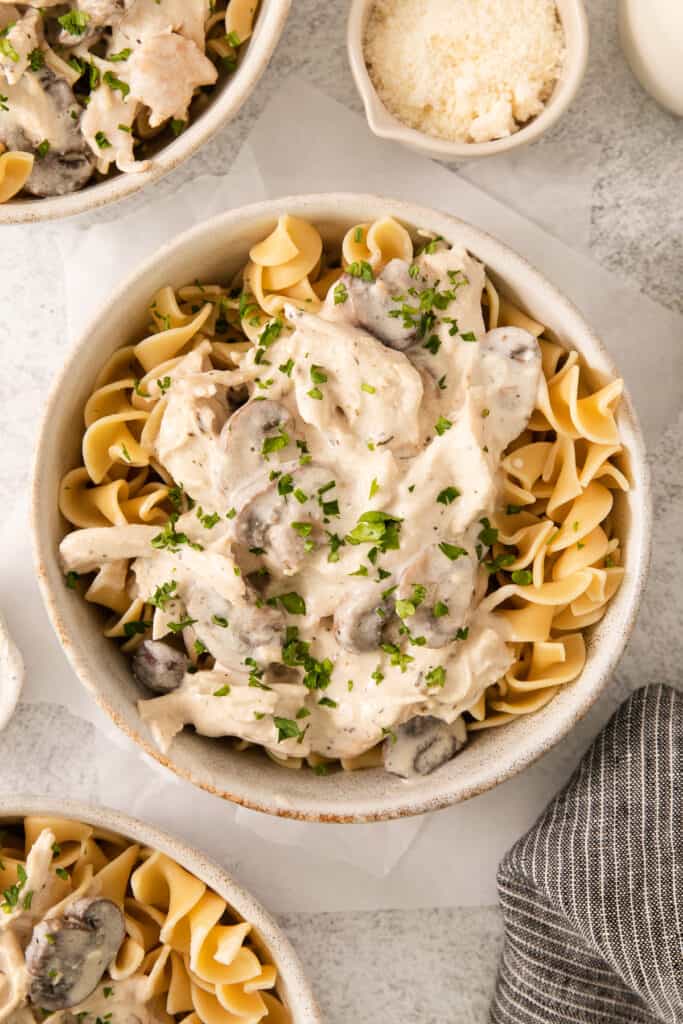 a bowl of pasta with mushroom sauce and parmesan cheese.