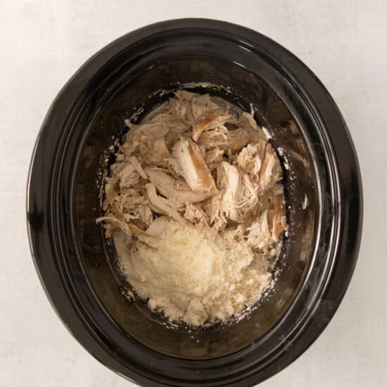 a bowl of chicken and rice in a slow cooker.
