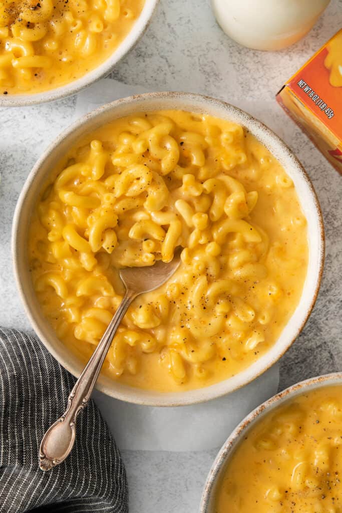 a bowl of macaroni and cheese with a spoon.
