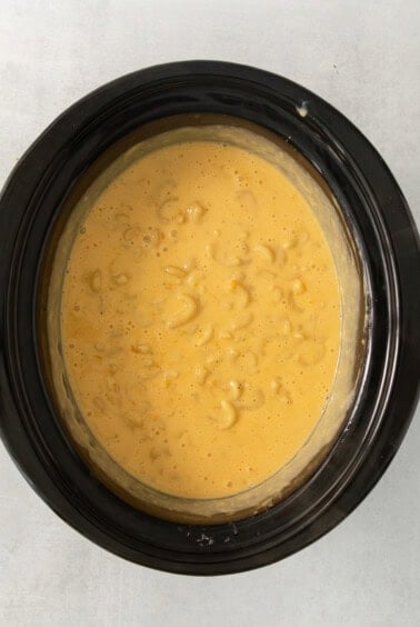 a bowl of macaroni and cheese in a slow cooker.