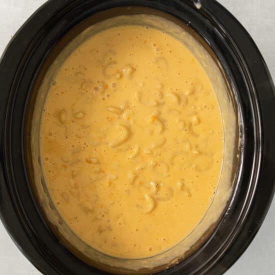 a bowl of macaroni and cheese in a slow cooker.