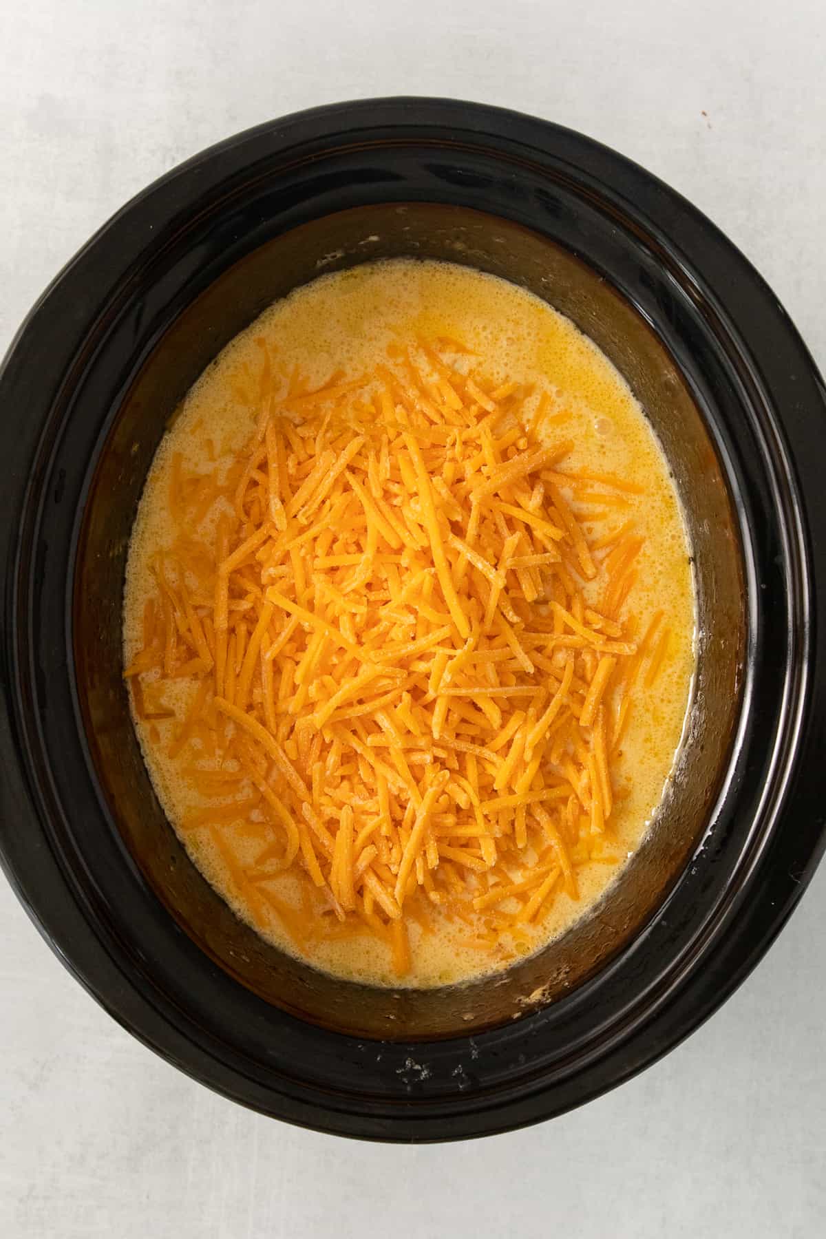 a bowl of cheesy chow mein in a slow cooker.