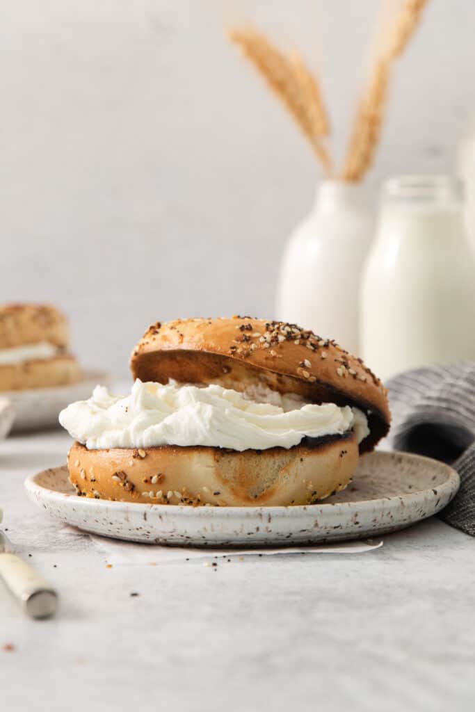 a bagel with cream cheese on a plate.