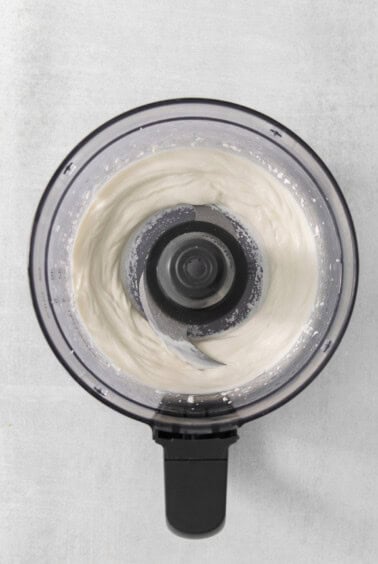 a close up of a food processor with whipped cream.