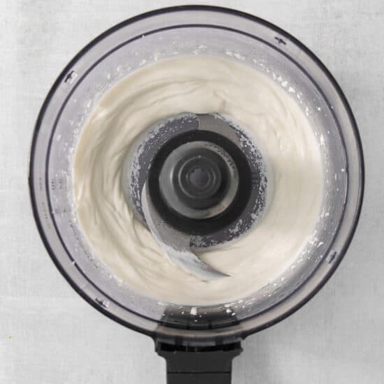 a close up of a food processor with whipped cream.