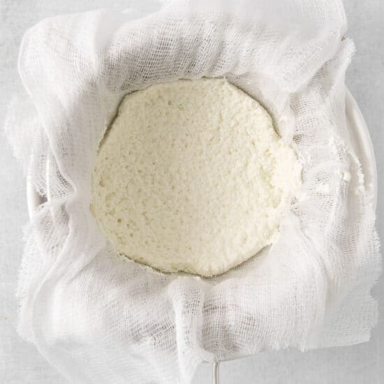 ricotta cheese in a cloth bag on a white background.