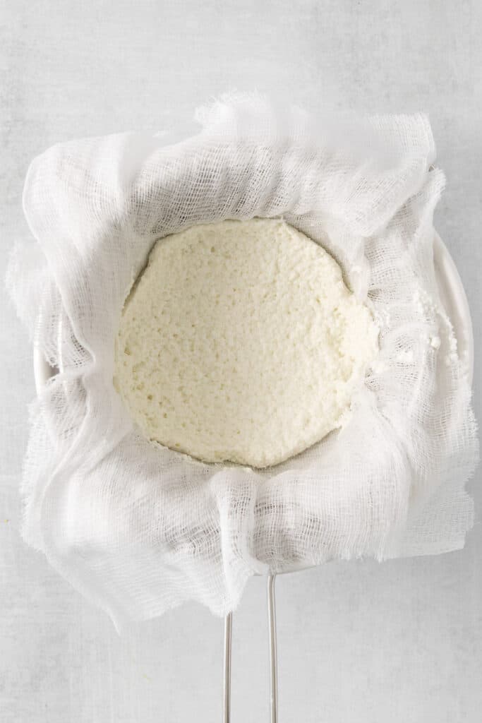 ricotta cheese in a cloth bag on a white background.