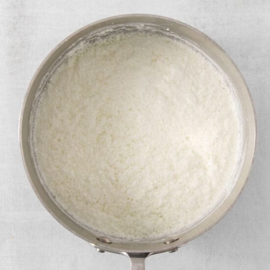 white rice in a pan on a white background.