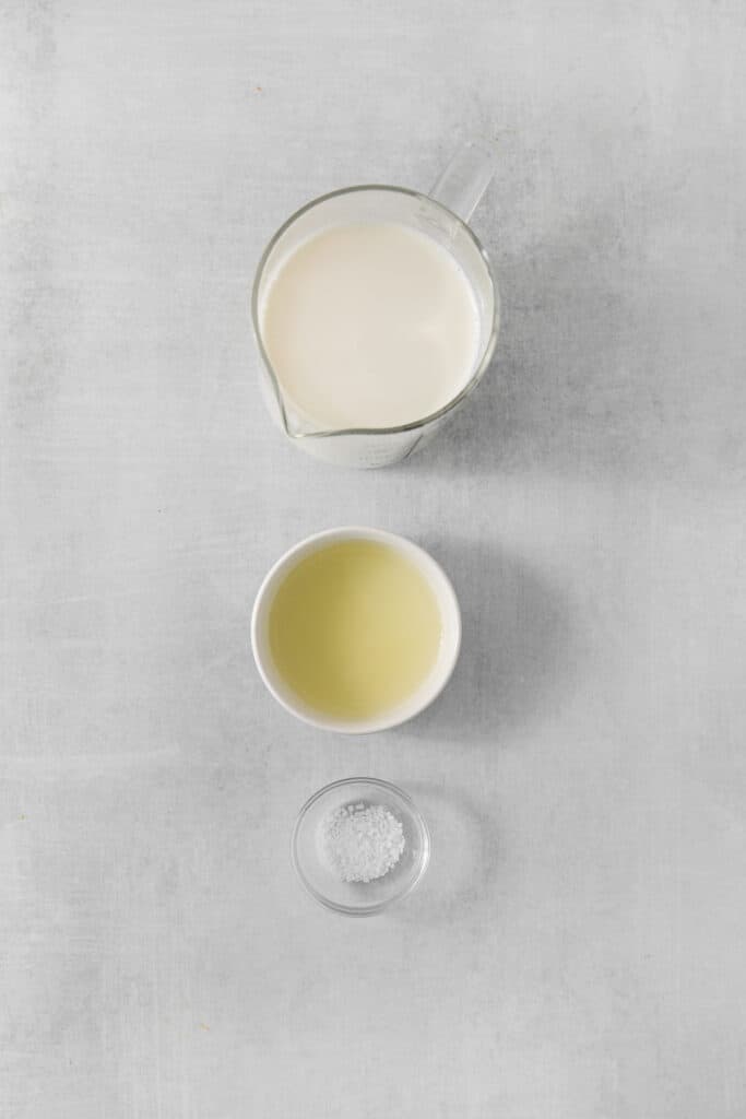a bowl of milk and a bowl of sugar on a gray background.