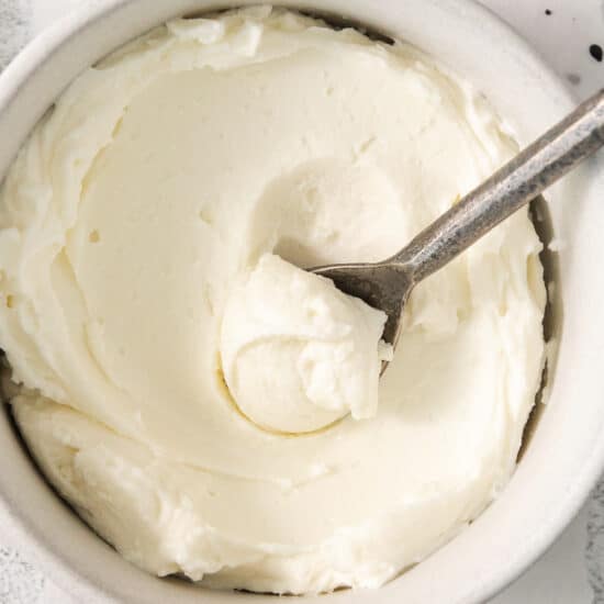 whipped cream in a bowl with a spoon.