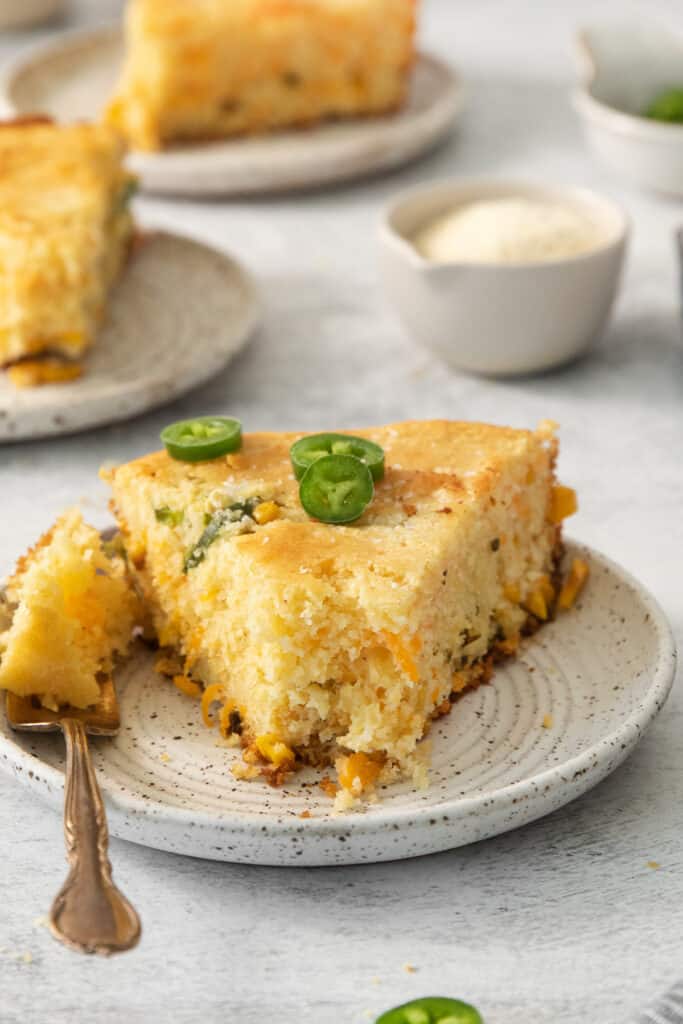 a slice of cornbread with jalapenos on a plate.