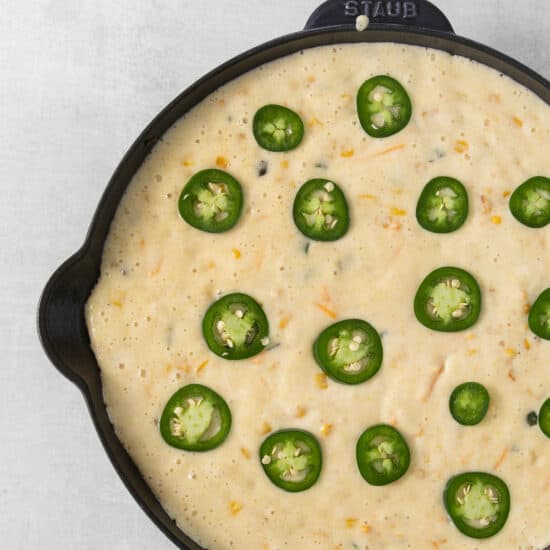 jalapeo cheese dip in a skillet with jalapeos.