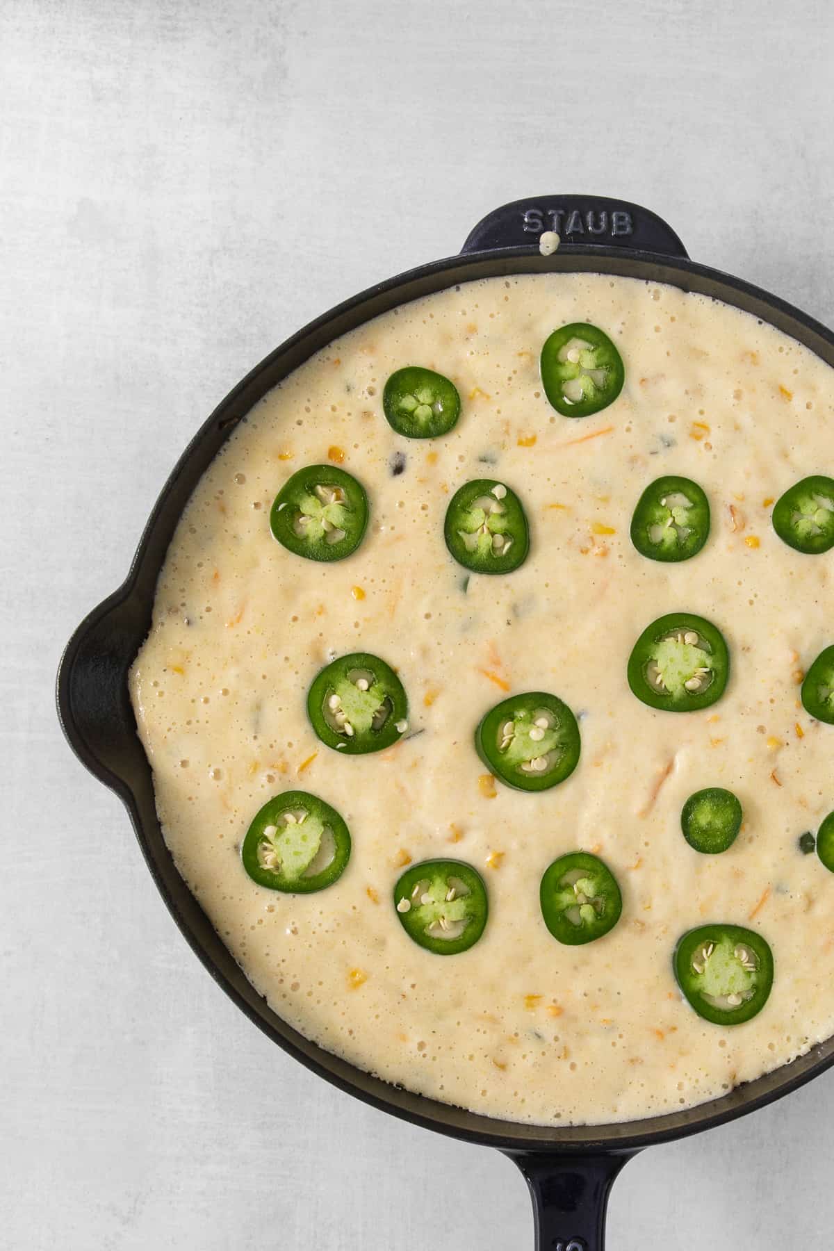 jalapeo cheese dip in a skillet with jalapeos.