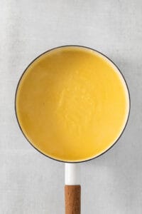 a yellow pan with a wooden handle on a white table.