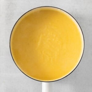 a yellow pan with a wooden handle on a white table.