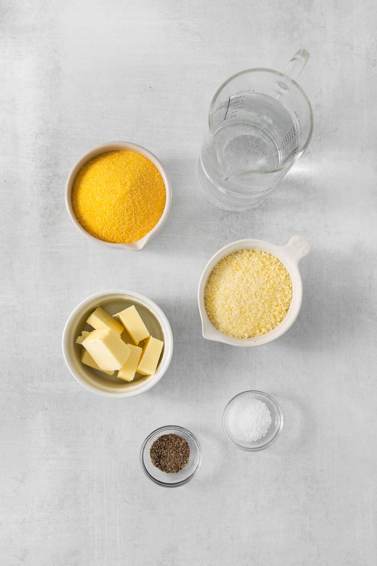 a table with bowls of food and a pitcher of water.