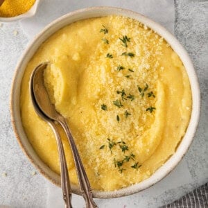 a bowl of mashed potatoes with a spoon in it.